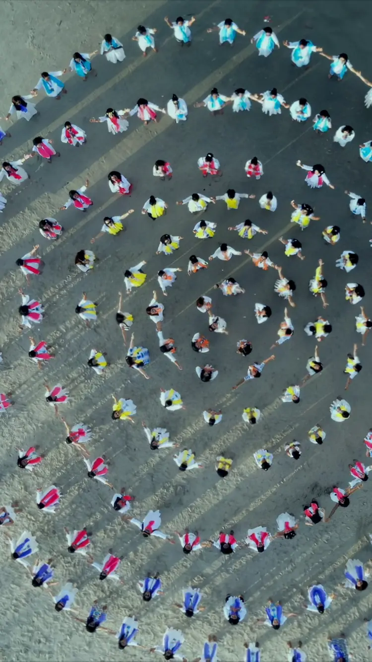 Women in a spiral on the sand in Goa, seen from above